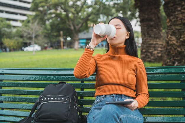 コーヒーを飲みながらタブレットを使用してアジアの女性。