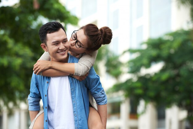 Asian Woman Enjoying Piggyback Ride on Boyfriend