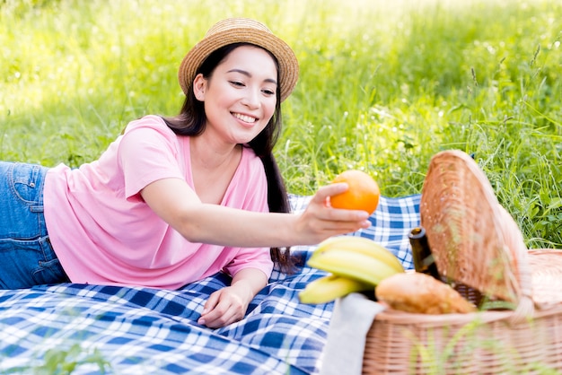 アジアの女性がオレンジを手で押し