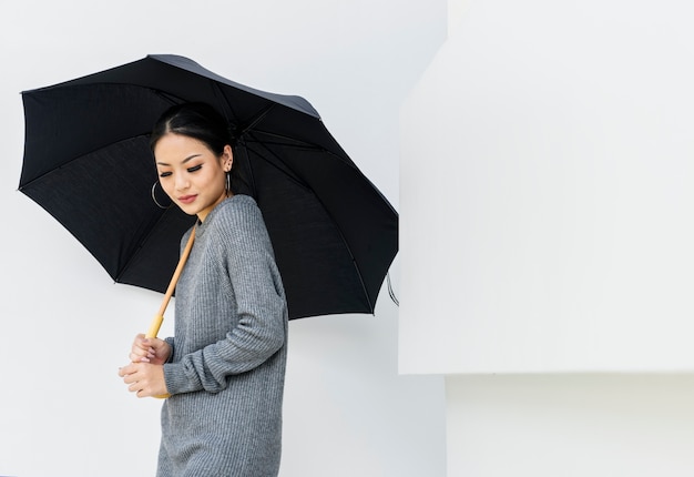 Бесплатное фото Азиатская женщина, держащая зонтик на белом фоне