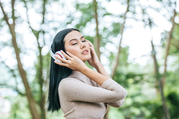 Asian woman listening favorite music on headphones. Happy time and relax.