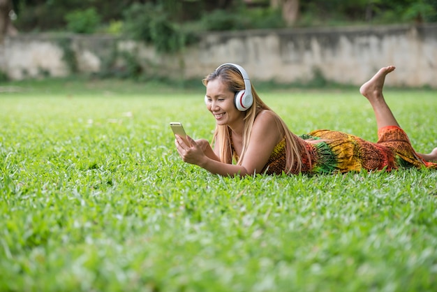 헤드폰에서 좋아하는 음악을 듣고 아시아 여자입니다. 행복한 시간과 휴식.