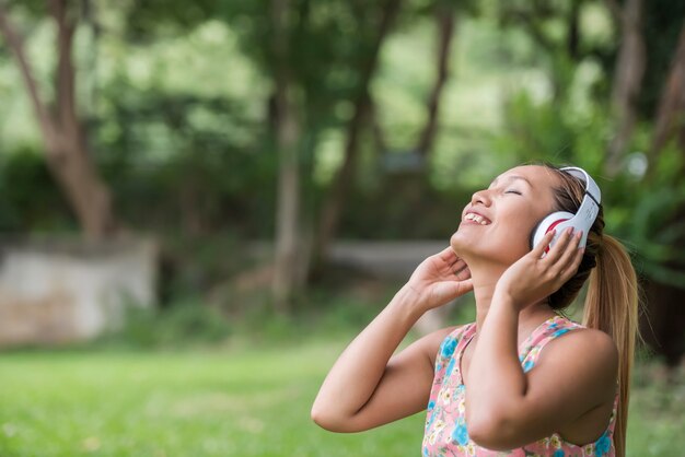 Asian woman listening favorite music on headphones. Happy time and relax.