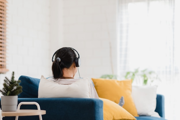 Musica d'ascolto della donna asiatica e tavola usando