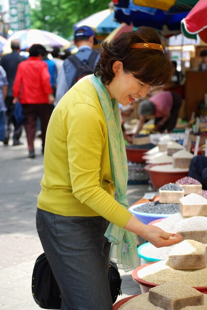 Asian woman looking at grains in market