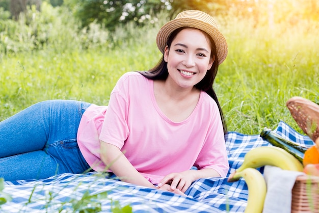 Азиатская женщина, лежа на ткани для пикника