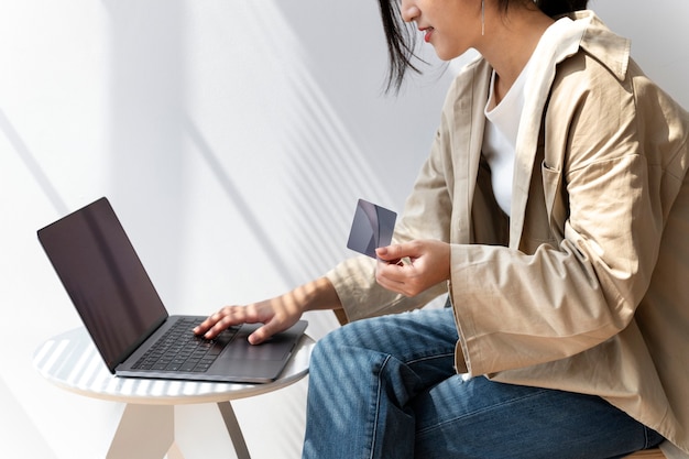 Азиатская женщина делает покупки в Интернете с помощью своего ноутбука