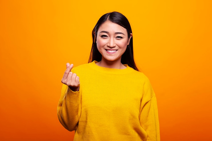 Free Photo asian woman posing with a finger heart