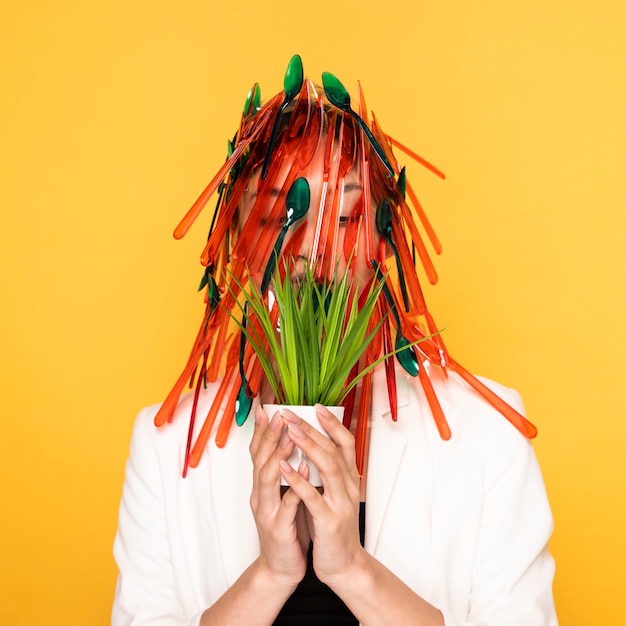 Asian woman posing with red and green plastic tableware on her