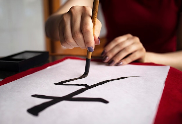 Asian woman practicing japanese handwriting indoors