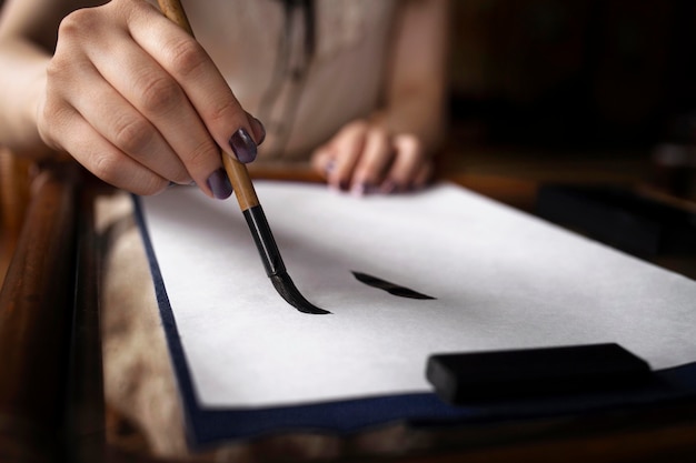 Free photo asian woman practicing japanese handwriting indoors