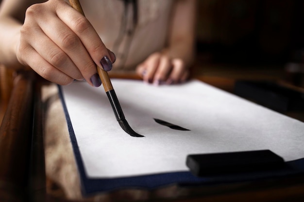 Азиатская женщина практикует японский почерк в помещении