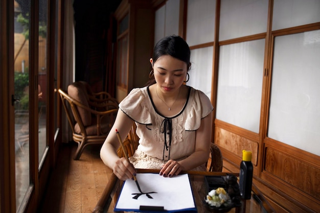 실내에서 일본어 필기를 연습하는 아시아 여성