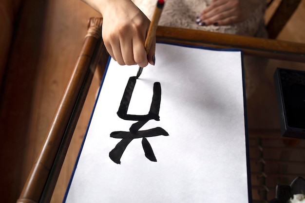 Free photo asian woman practicing japanese handwriting indoors