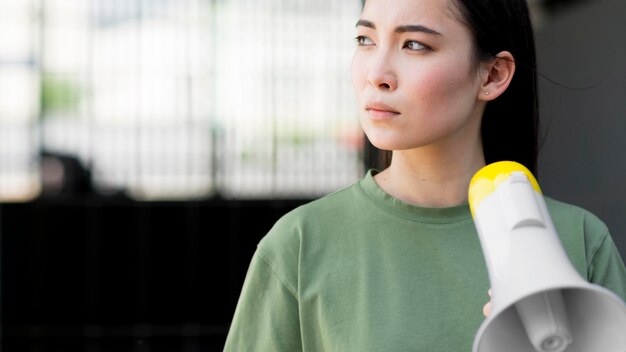 Asian woman protesting and holding megaphone