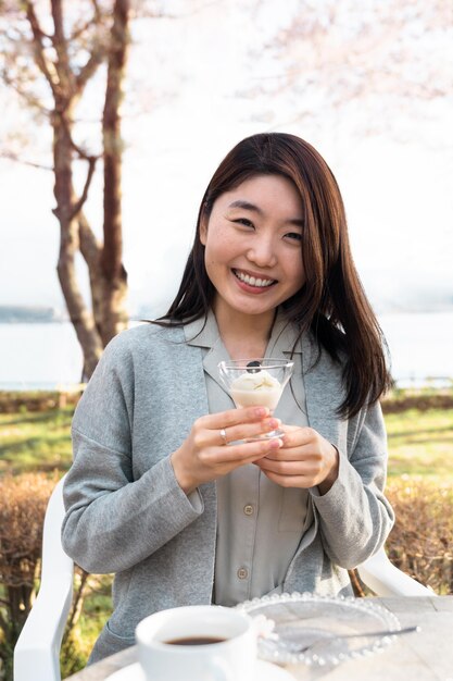 Asian woman relaxing outdoors next to a cherry tree