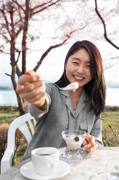 無料写真 桜の木の横で屋外でリラックスするアジアの女性