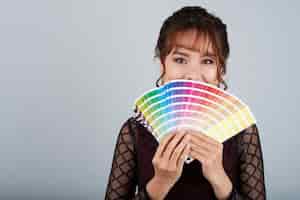 Foto gratuita donna asiatica che mostra la tavolozza dei colori che copre la sua bocca di esso