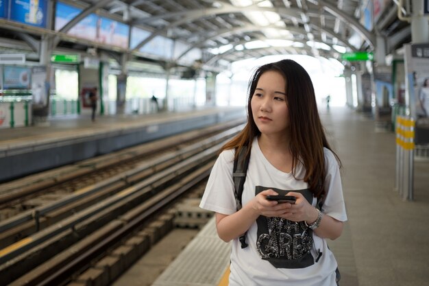 旅行中にスマートフォンを使用してアジアの女性の観光客