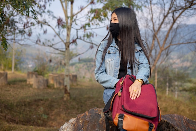 얼굴 마스크를 착용하는 아시아 여자 관광. 코로나 바이러스 독감 바이러스 여행 컨셉