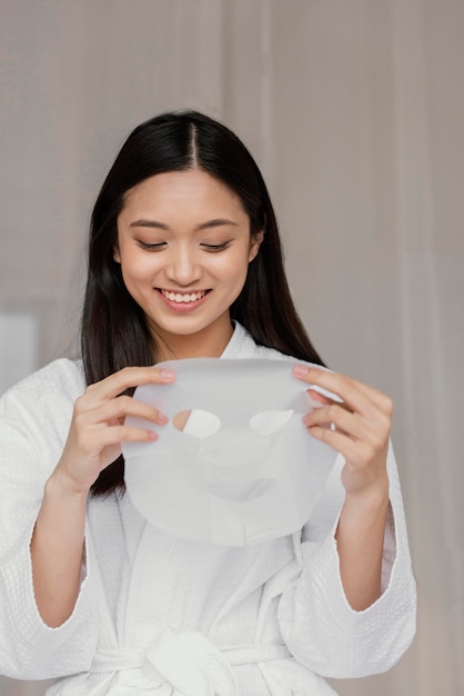 Бесплатное фото Азиатская женщина, использующая маску листа