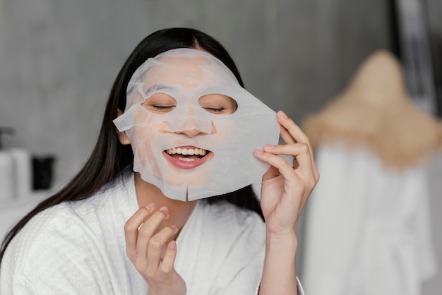 Free photo asian woman using a sheet mask