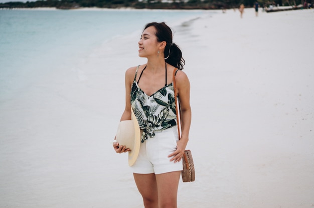 Foto gratuita donna asiatica in vacanza in spiaggia