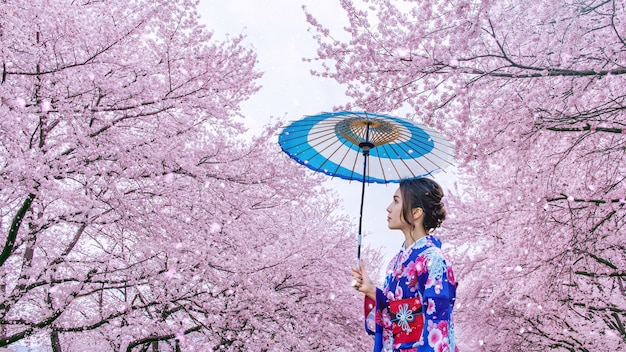 日本の春に日本の伝統的な着物と桜を着ているアジアの女性。