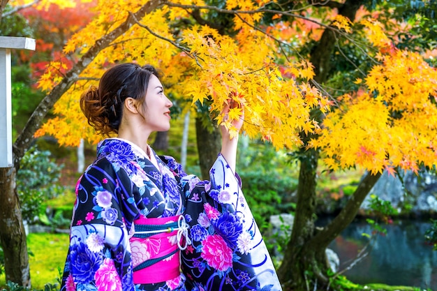 Foto gratuita donna asiatica che indossa il kimono tradizionale giapponese nella sosta di autunno. giappone