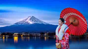 Free photo asian woman wearing japanese traditional kimono at fuji mountain, kawaguchiko lake in japan.