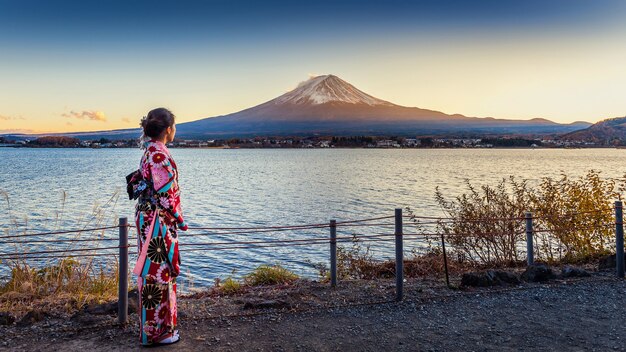 富士山で日本の伝統的な着物を着ているアジアの女性。日本の河口湖に沈む夕日。