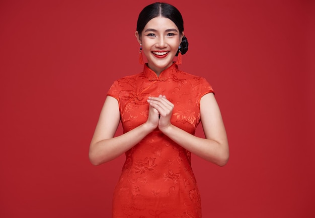 Asian woman wearing traditional cheongsam qipao dress with gesture of congratulation
