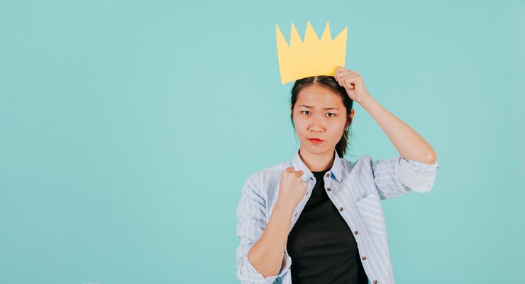 無料Photo 強く身を包む紙クラウンを持つアジアの女性