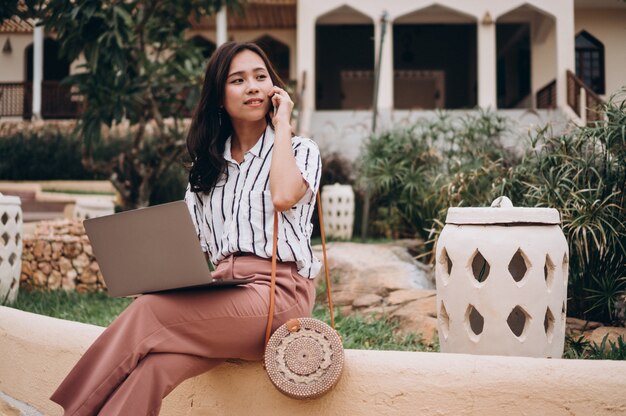 Asian woman working on laptop on a vacation