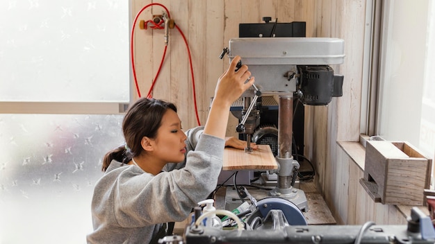 Asian woman working with wood medium shot