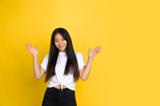 Asian woman on yellow wall, emotions