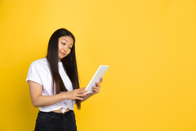 Asian woman on yellow wall, emotions