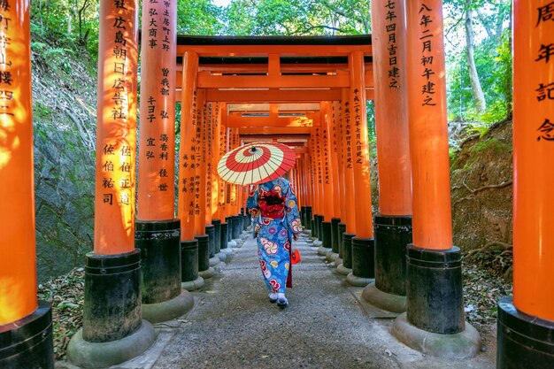 일본 교토의 후 시미이나 리 신사에서 일본 전통 기모노를 입은 아시아 여성.