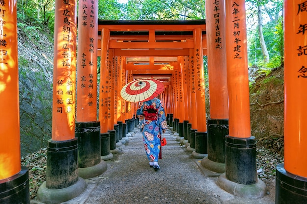 京都の伏見稲荷神社で伝統的な日本の着物を着たアジアの女性。