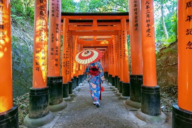 京都の伏見稲荷神社で伝統的な日本の着物を着たアジアの女性。