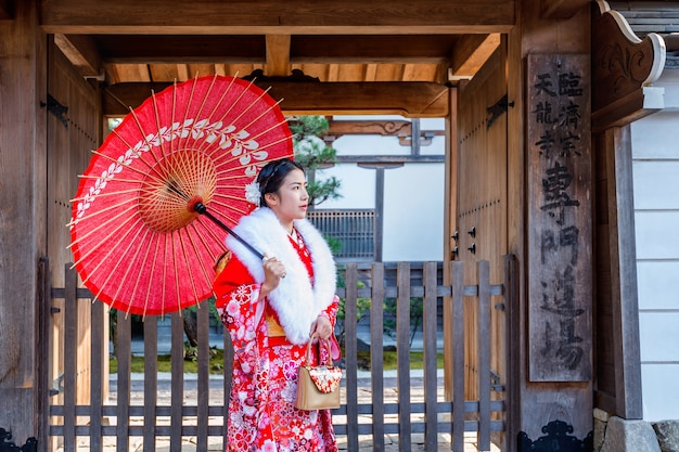 日本の伝統的な着物を着たアジアの女性が京都の美しい場所を訪れます。