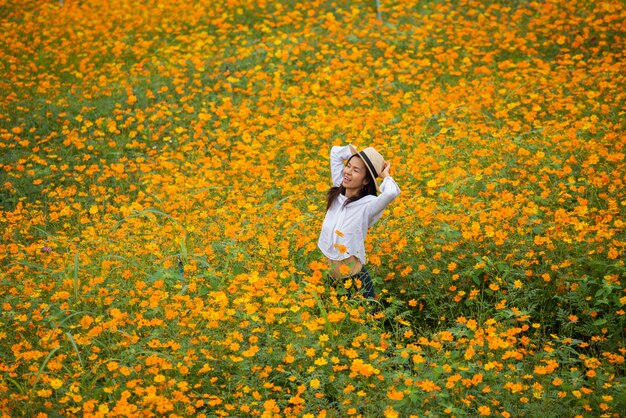 黄色の花農場でアジアの女性