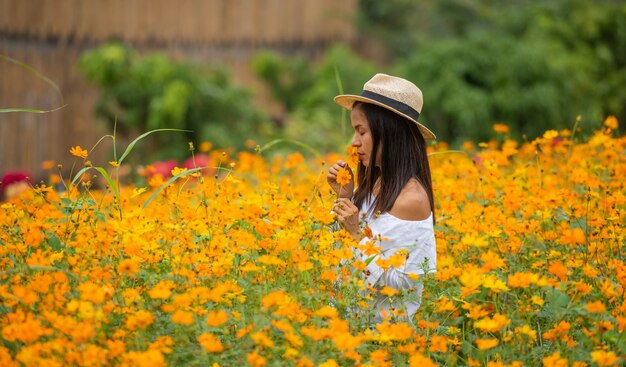 黄色の花農場でアジアの女性