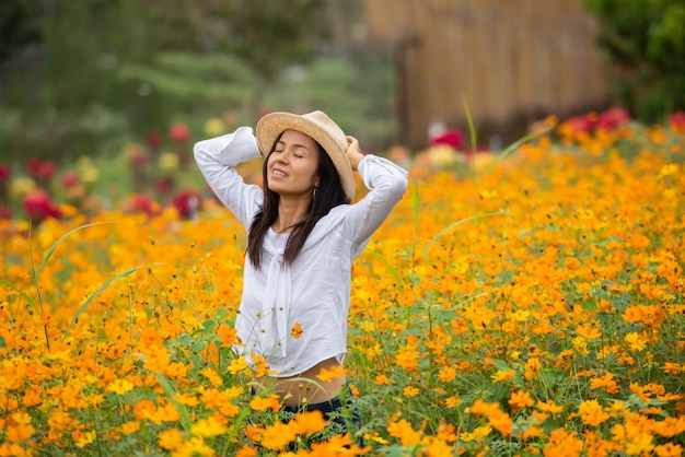 黄色の花農場でアジアの女性