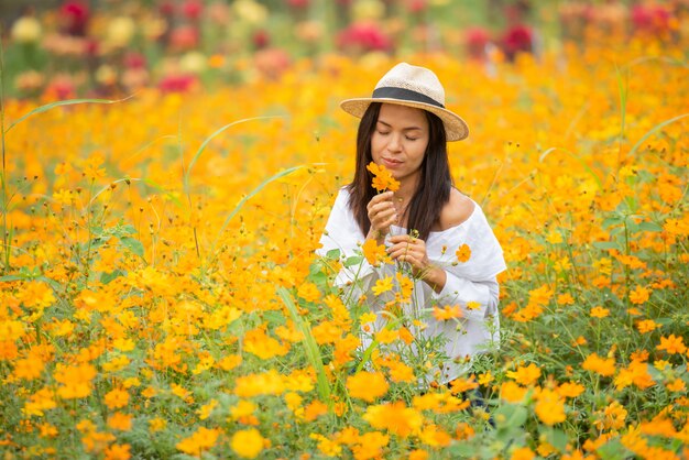 黄色の花農場でアジアの女性