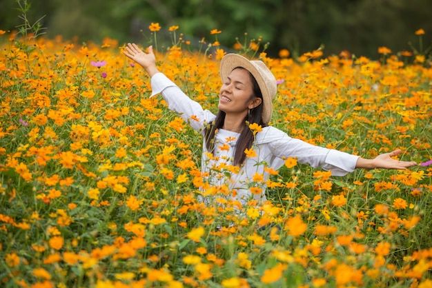 黄色の花農場でアジアの女性