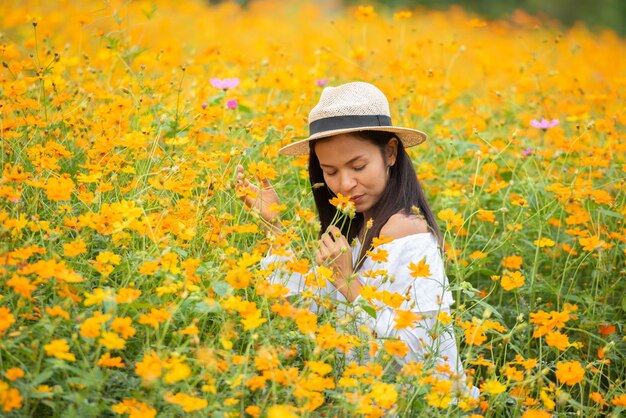 黄色の花農場でアジアの女性