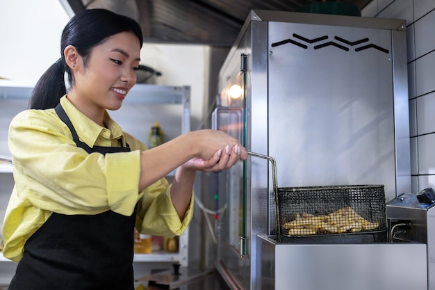 Foto gratuita ragazza asiatica che lavora in cucina e prepara il cibo