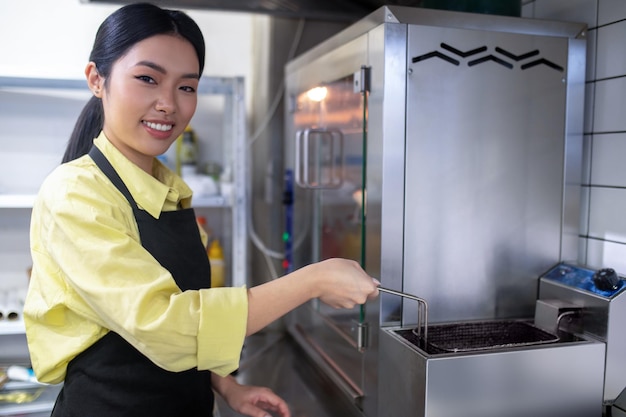 Ragazza asiatica che lavora in cucina e prepara il cibo