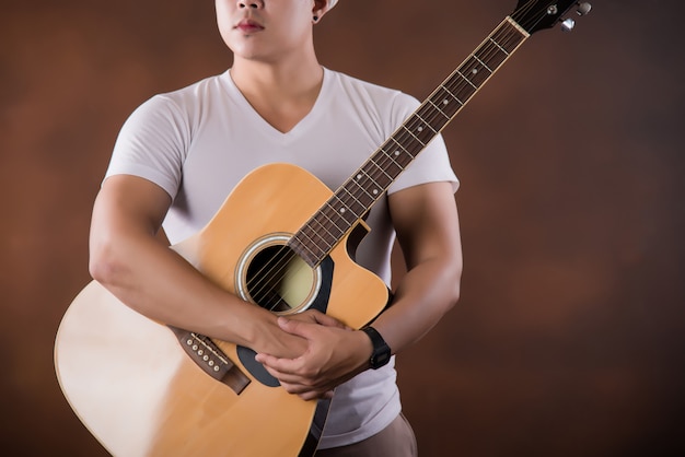 アコースティックギターとアジアの若い男ミュージシャン
